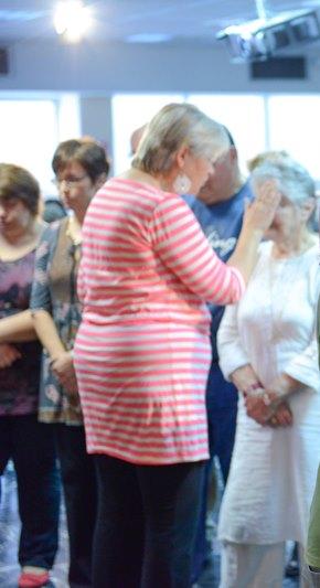 קטרינה דורון מתפללת עבור אישה אחרת בקהילת תפארת ישוע